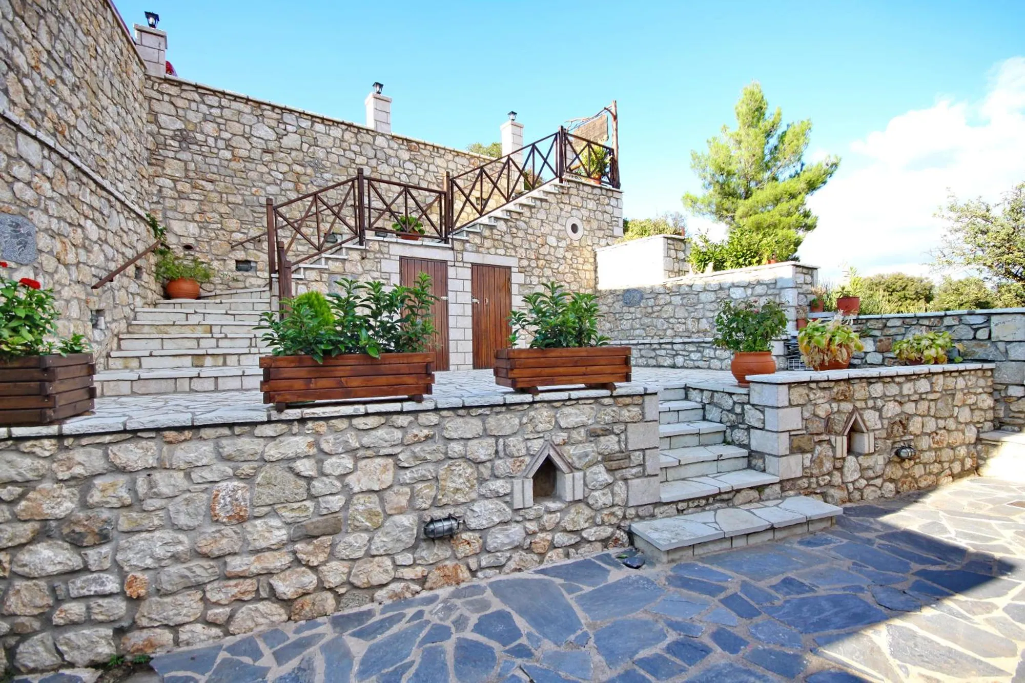 Η πέτρινη αυλή με τις σκάλες και τα λουλούδια