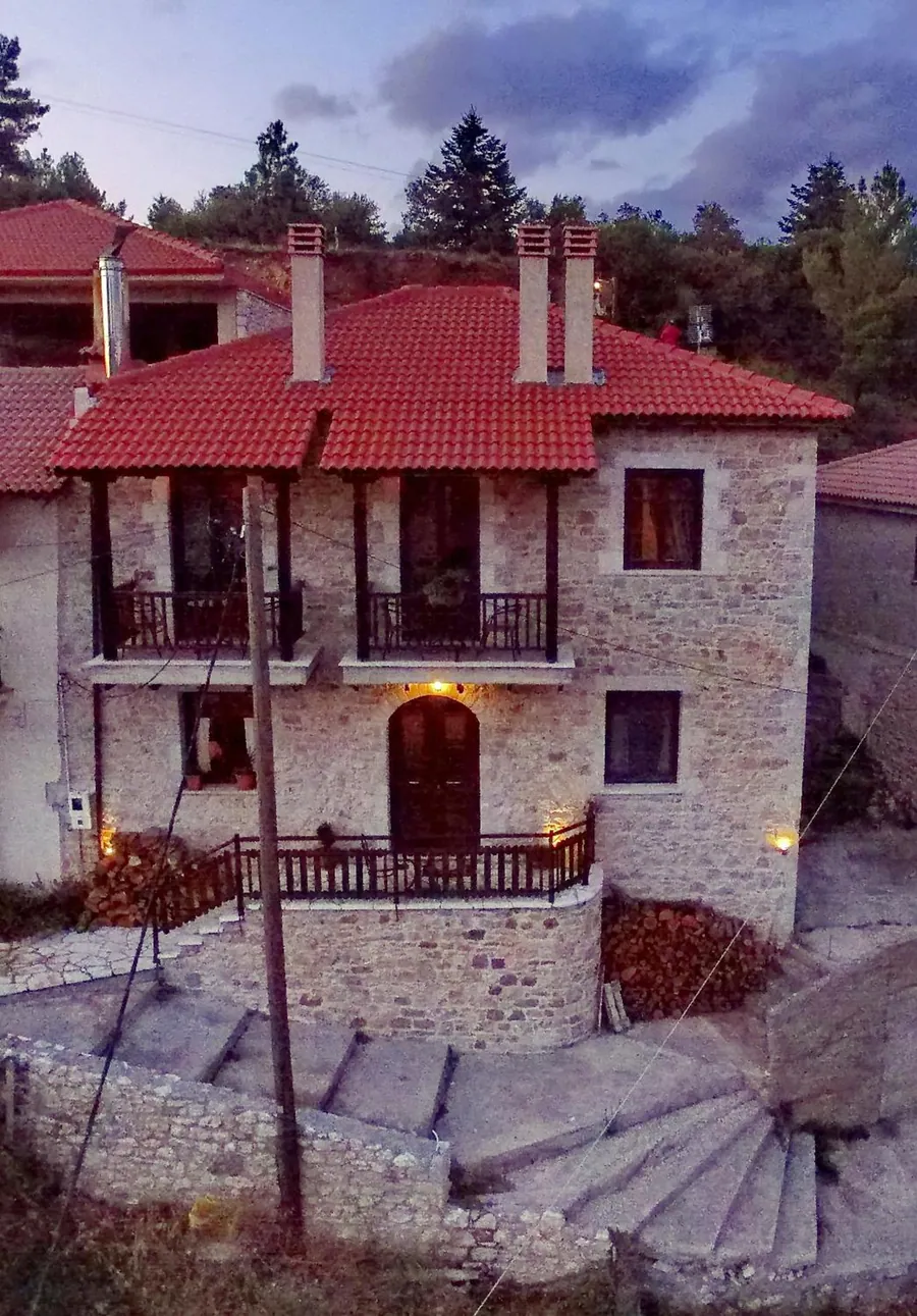 Ο πέτρινος ξενώνας φωτισμένος το σούρουπο